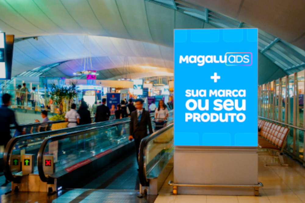 Painel de mídia em aeroporto com pessoas circulando